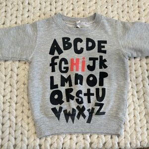 A unisex alphabet “HI” sweatshirt in size 2T